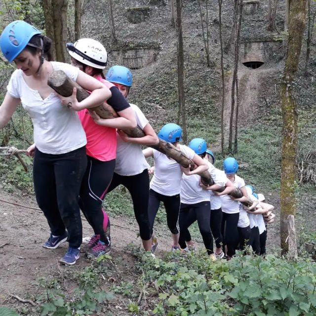 File de participants casqués portant un tronc devant le Fort de Vancia