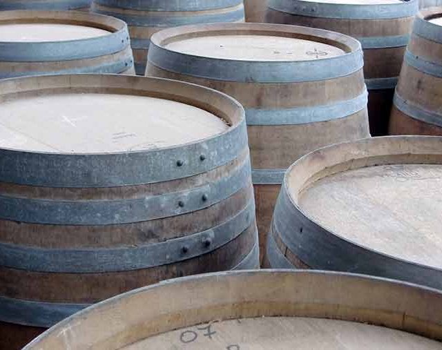 Tonneaux de chêne alignés dans une cave vinicole du château de Saint-Émilion