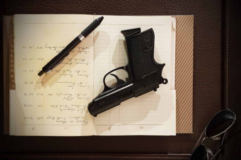Carnet écrit à la main avec stylo et pistolet noir posés dessus, salle Opération Balkans chez Quest Factory à Paris