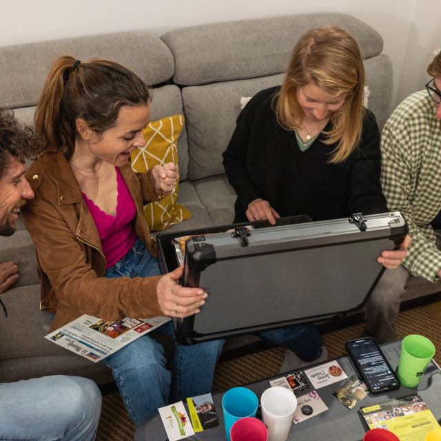 Quatre joueurs autour d'une table avec énigmes et accessoires chez Escape Game Apéro 79