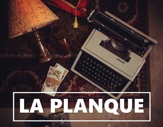 Machine à écrire, lampe et papiers sur un tapis, titre La Planque en lettres blanches, salle La Planque