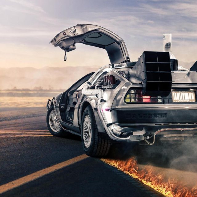 Voiture futuriste aux portes ouvertes, panneaux solaires et tableau de bord technologique, paysage désertique en flammes