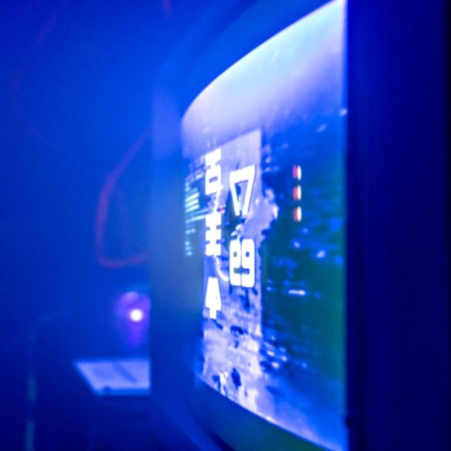 Grand écran d'interface bleu sur un mur sombre, salle La reine rouge chez Wood Escape à Locquignol