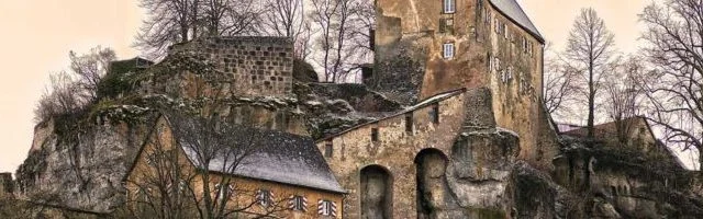 Château de pierre aux tours massives parmi les arbres nus d'hiver