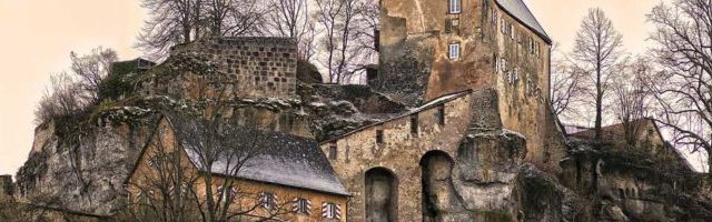 Château de pierre aux tours massives parmi les arbres nus d'hiver