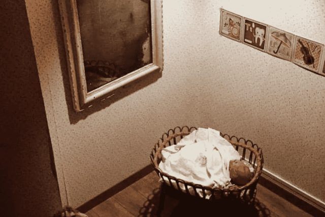 Coin de chambre aux tons sépia avec un miroir et un panier de linge blanc, salle La petite Chambre chez Casse-Tête Bordelais