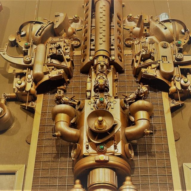 Mécanisme doré symétrique avec engrenages et sphères, esthétique steampunk chez Playheure