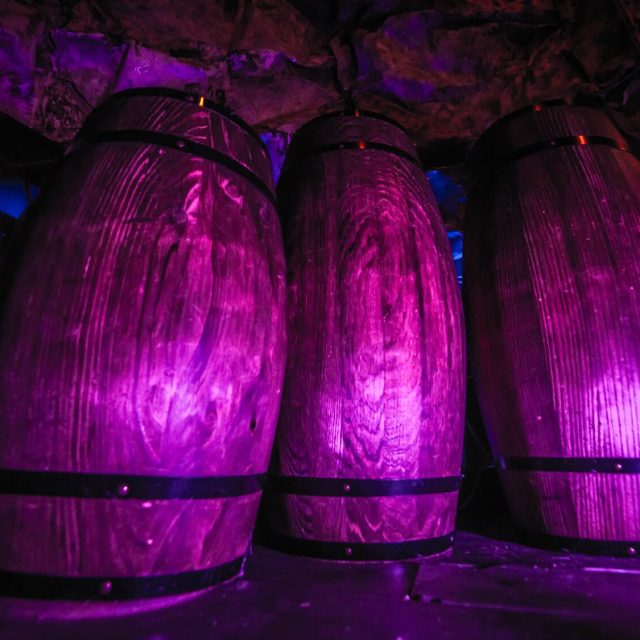 Trois capsules violettes illuminées dans le décor pirate du Navire maudit