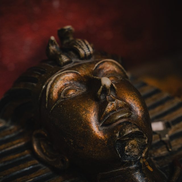 Masque de pharaon en bronze en gros plan, salle Le temple chez Leave in time à Paris