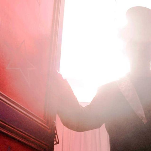 Silhouette d'une personne en contre-jour devant une porte rouge dans Escape Circus