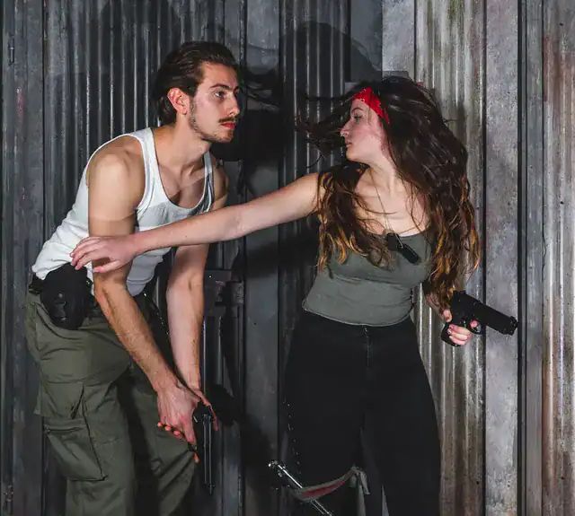 Duo armé progressant le long d'un mur de tôle, salle Amazonia
