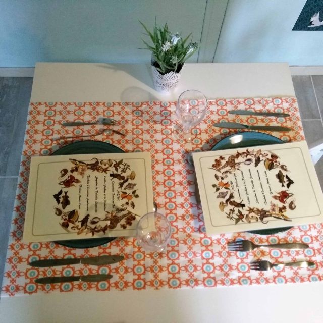 Vue de dessus d'une table à deux couverts et de napperons à couronne de fleurs, salle Les poulettes à Villemandeur