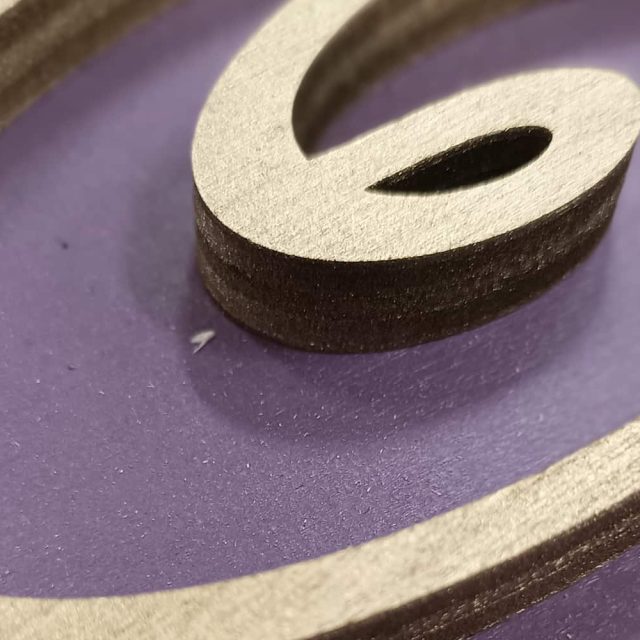 Lettre G découpée dans du bois clair sur fond violet, décor de la salle La mystérieuse roulotte à La Roche-sur-Yon