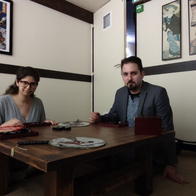 Deux joueurs autour d'une table en bois dans une salle au décor japonais épuré chez Closed Escape Game