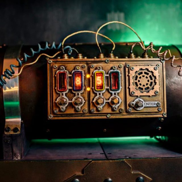 Boîtier steampunk à fils de cuivre et affichages lumineux sur fond vert, salle Sherlock Holmes chez Freeing à Saint-Maximin