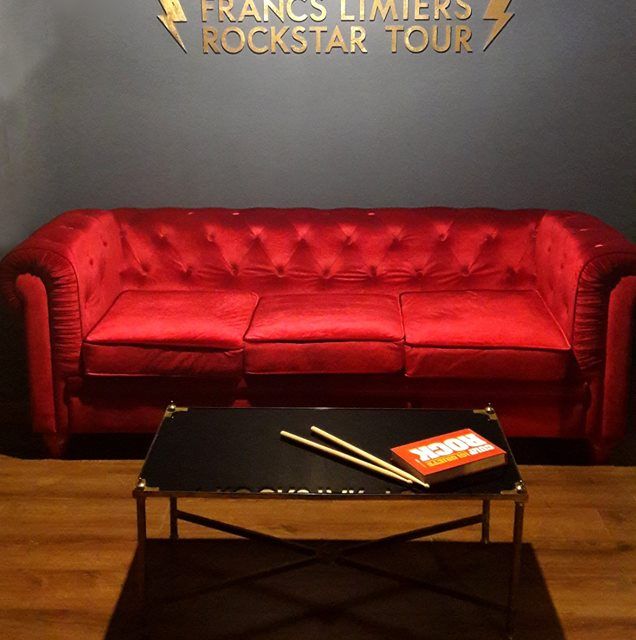Canapé rouge et table basse dans la salle Rockstar Tour des Francs Limiers