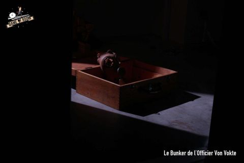 Petite caisse en bois éclairée dans le noir, légende Le Bunker de l'Officier Von Vokte, salle chez Game of Room à Villeurbanne