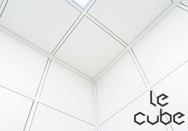 Angle de pièce blanche aux panneaux géométriques et mot Le cube en bas à droite, One Brain à Lille