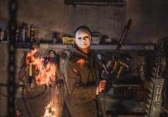 Homme en tenue de pompier face aux flammes dans un décor industriel sombre chez EXITROOM Berlin