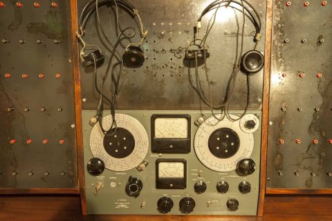 Ancien tableau de bord électronique avec cadrans, écouteurs et connexions dans Breizh Escape Dinard