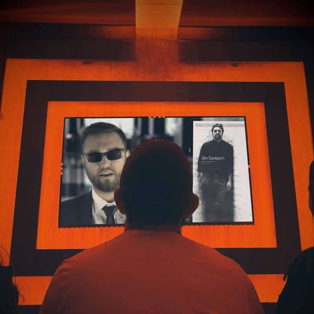 Joueur face à écrans affichant des portraits dans décor orange, salle CIA : porté disparu chez Freeing! à Saint-Maximin