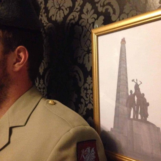 Homme face à un tableau montrant un monument et des silhouettes dans la salle Le rapport de l'agent Petra