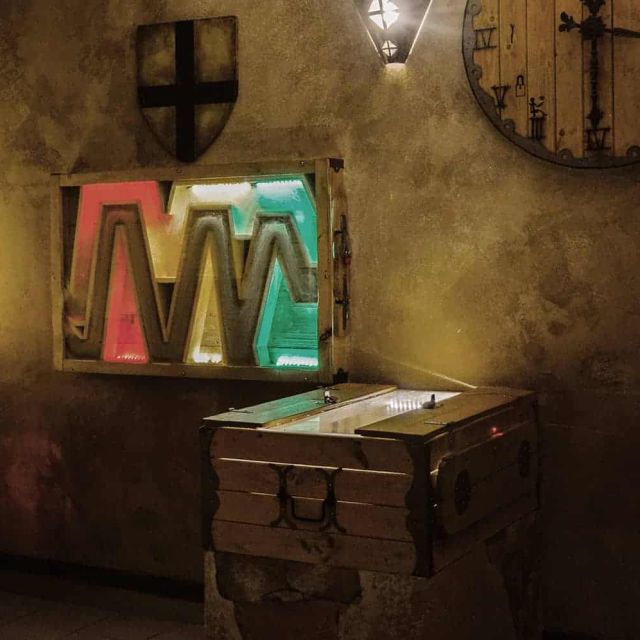 Pièce voûtée avec blason, horloge et pupitre à écran lumineux, salle Les cachots du chevalier noir, Happy Hour à Paris