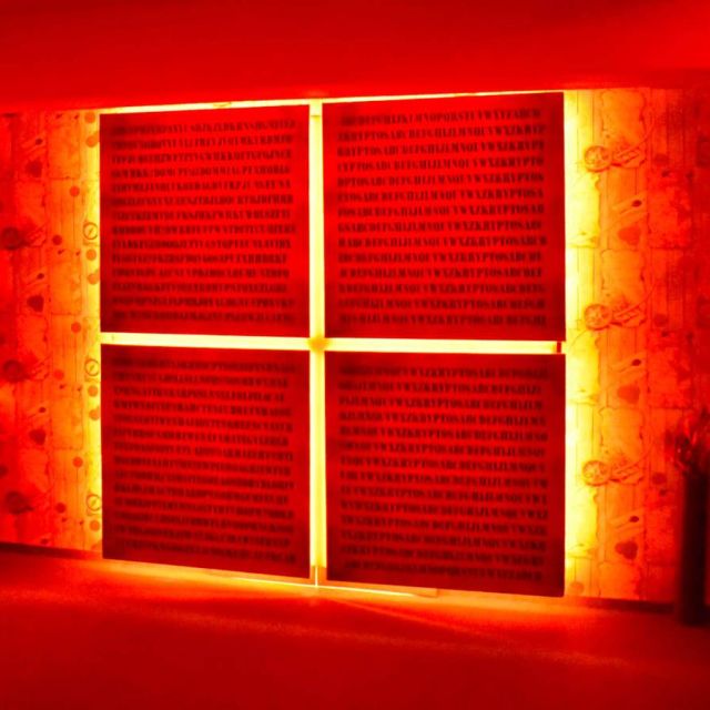 Panneaux lumineux rouges et or avec textes, décor énigmatique de la salle CIA : porté disparu chez Freeing!