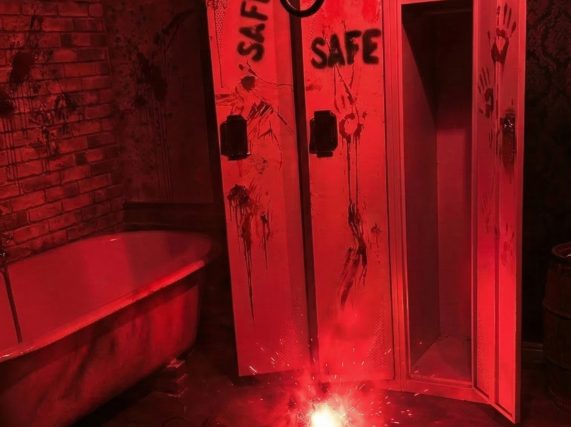Décor rouge sang avec pendelaison, coffre-fort ouvert et empreintes sanglantes dans L'abattoir