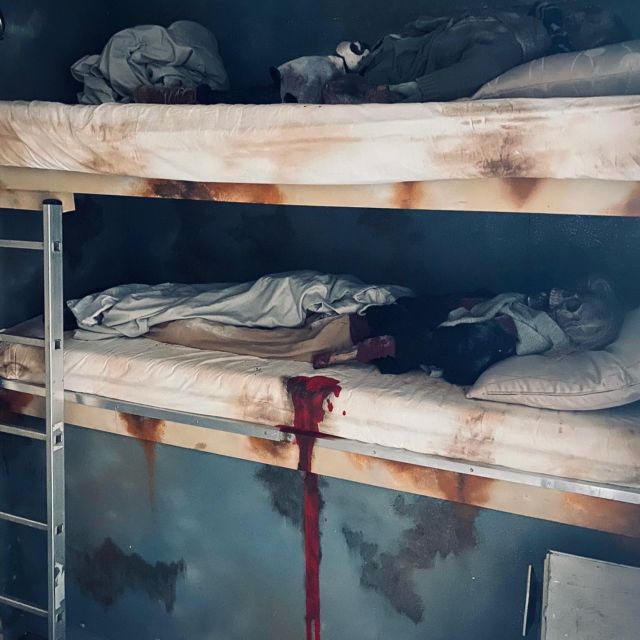 Lits superposés aux draps tachés de rouge, décor de la salle Panic Room