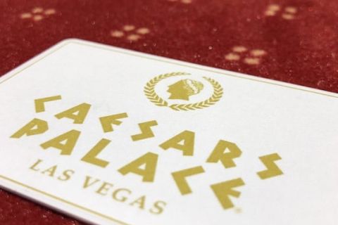 Carton blanc avec lettres dorées Casars Palace sur tapis rouge perlé