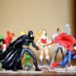 Figurines de super-héros alignées sur fond beige clair