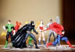 Figurines de super-héros alignées sur fond beige clair
