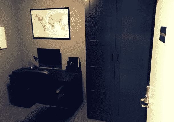 Entrée discrète avec porte noire, bureau et carte murale, ambiance professionnelle chez Fun shine