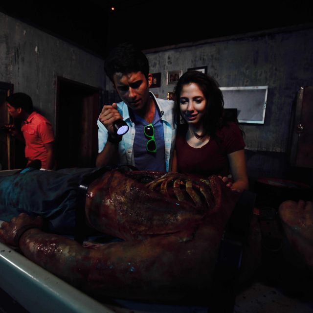 Équipe d'aventuriers découvrant une momie dans une salle sombre chez Lockbusters Escape Game Orlando