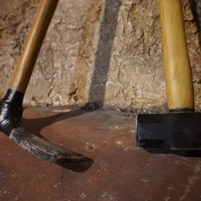 Outils de mineur posés sur le sol rocheux de la mine Des intrus dans la mine