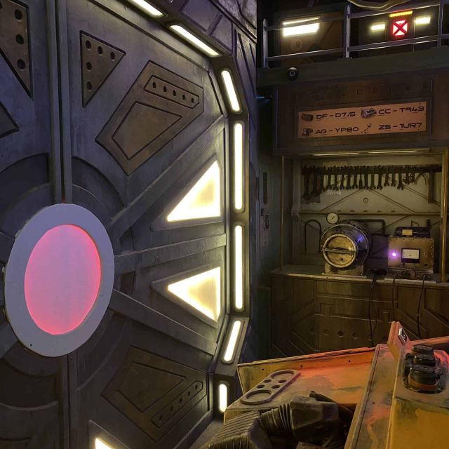 Intérieur de vaisseau spatial avec tableau de bord illuminé et hublot rose, chez Mastermind à Bern