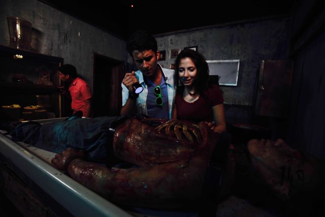 Joueurs examinent une momie dans un décor sombre chez Lockbusters Escape Game Orlando