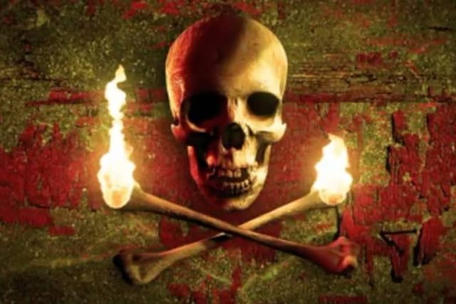Crâne aux flammes et os croisés sur mur délabré, thème pirate du Vaisseau Fantôme