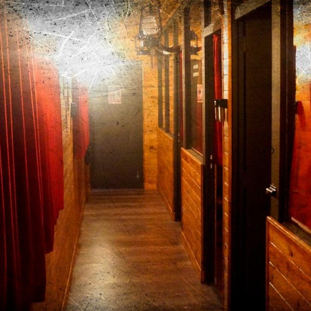 Couloir souterrain aux murs rouges et ocres, portes noires, ambiance sombre dans le Silver Express