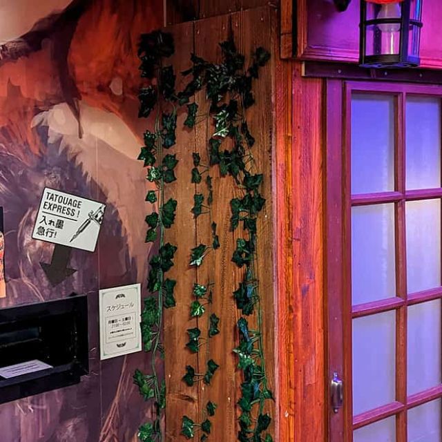 Mur de visuels de tatouages, enseigne japonaise et fenêtres à croisillons, salle Mission Tokyo chez Escape Time à Angers