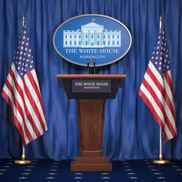 Pupitre officiel avec logo de la Maison-Blanche, drapeaux américains, rideau bleu dans la salle L'attaque de la Maison-Blanche